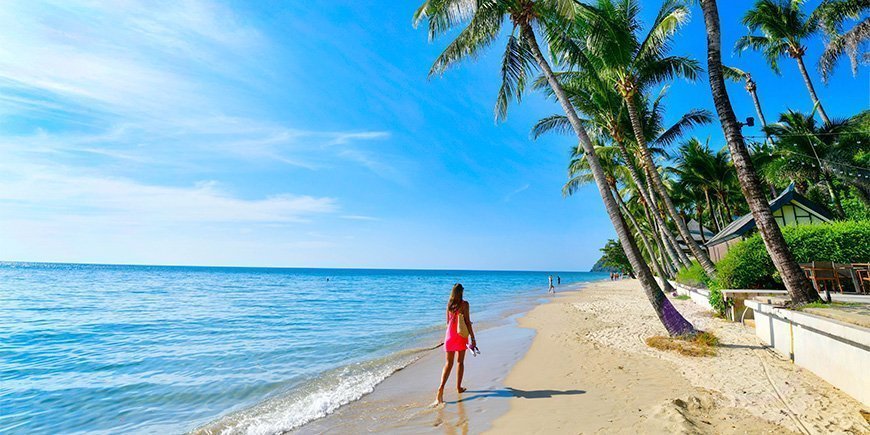 Kvinne går på stranden på Koh Chang i Thailand