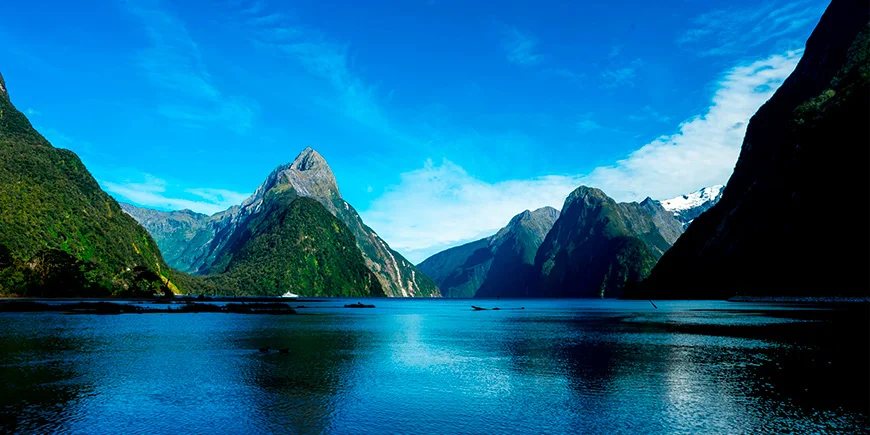Klart vær med blå himmel ved Milford Sound i New Zealand