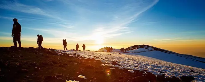 Vandrere på Kilimanjaro i solopgangen