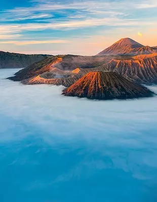 Vulkanfjellet Bromo ved soloppgang, innhyllet av morgentåke, Øst-Java, Indonesia